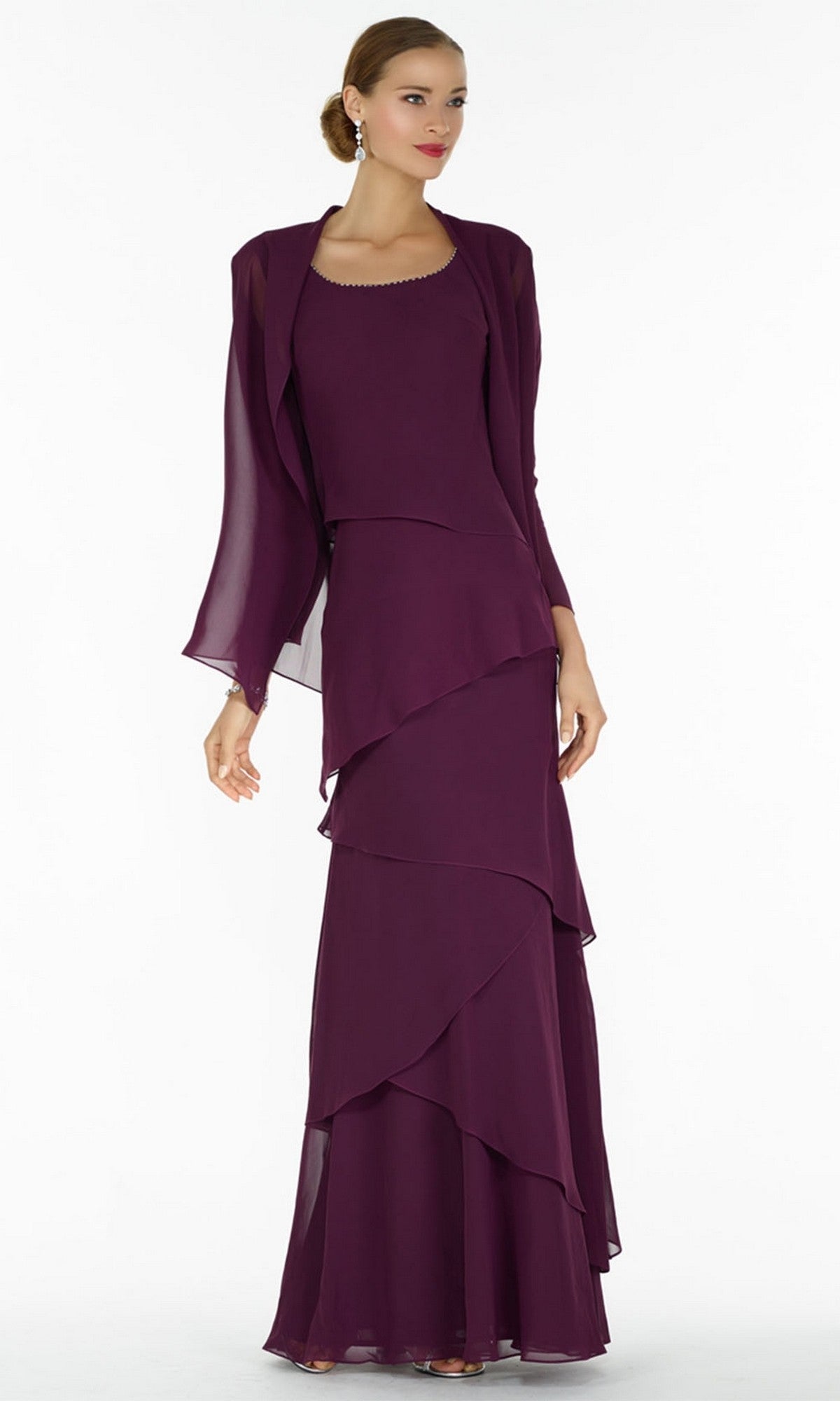 A woman in an eggplant Alyce 29292 long formal sleeveless dress with jacket and layered ruffles stands against a plain white background.